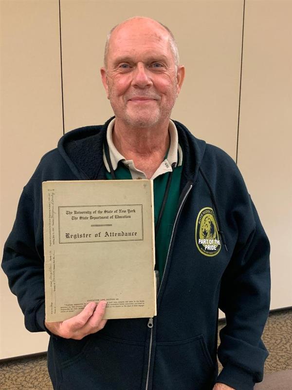 John Dreher holding an old school register